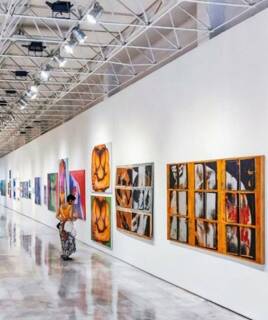 Femme rgardant un tableau se trouvant dans le Musée international des Arts Modestes